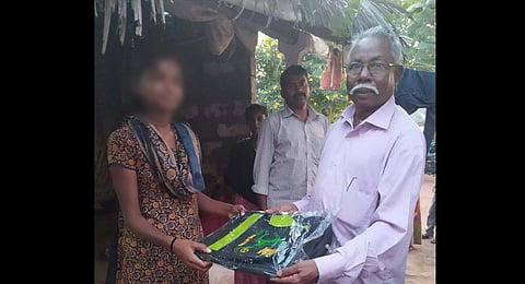 Thangasamy distributes school bag to tribal students in Valparai hill. (Photo | Special Arrangement)