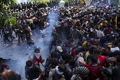 Protesters carrying Sri Lankan flags gathered outside the PM's office in Colombo, Sri Lanka. (Photo | AP)
