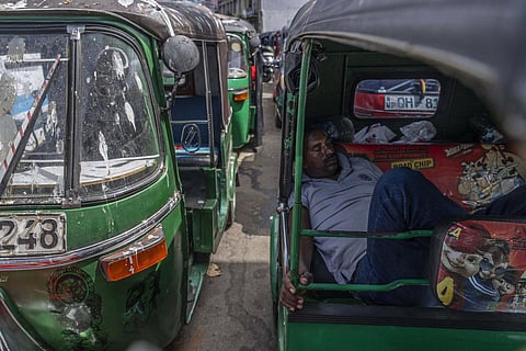 A driver of an autorickshaw sleeps inside his rickshaw while waiting in a queue to buy petrol at a fuel station, in Colombo, Sri Lanka. (Photo | AP)