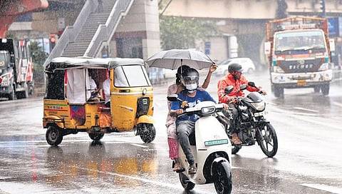 Commuters shield themselves from the rain using an umbrella in Hyderabad on Tuesday | Vinay Madapu