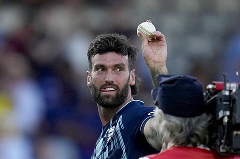 England's Reece Topley walks off the field of play with the ball at the end of the match after taking six wickets in the second one day international cricket match between England and India (AP)