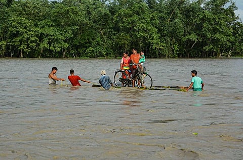 Villagers on a banana raft move to a safer place from the flooded area of Goalbil in Baksa district of Assam. (File Photo | PTI)