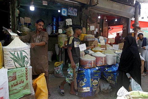 A woman prices foodstuff from a shopkeeper at a market, in Karachi, Pakistan. (Photo |AP)