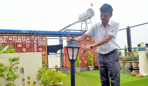 Sanjay Deshpande with a solar light on his terrace garden. (Photo | D Hemanth)