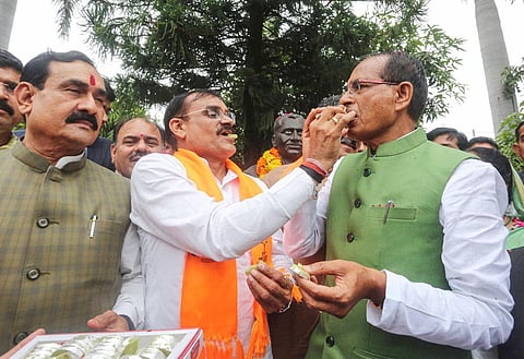 Madhya Pradesh CM Shivraj Singh Chouhan being offered sweets by MP BJP President VD Sharma as they celebrate the party's victory in the second phase of local bodies elections. (Photo | PTI)