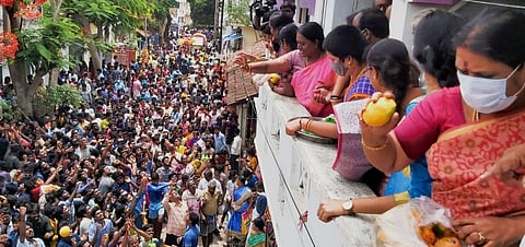 People toss mangoes from the balconies while the crowd catch them on the ground below during the Karaikal Mangani Thiruvizha. (Photo | H Jashwanth Kumar, EPS)