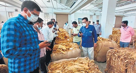 Traders take part in tobacco auctions at a platform of the Tobacco Board in Ongole.