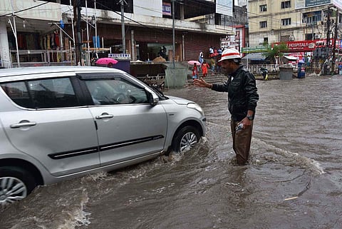 A policeman regulates traffic during heavy rain at Ameerpet. (Photo | Jwala)