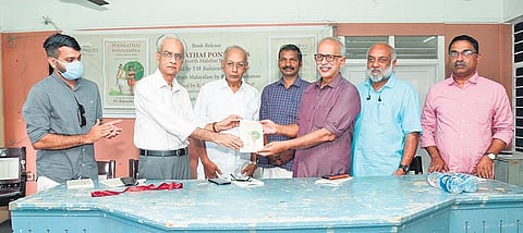 Former chief secretary K Jayakumar releasing the English translation of Poomathai Ponnamma by handing over a copy of the book to M G Sashibhooshan. Author P S Rajamohanan is also seen | Express