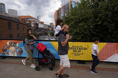 A family walks across a bridge over a canal displaying Commonwealth Games mascot, Perry the bull in Birmingham, England, Wednesday, July 27, 2022. (Photo | AP)