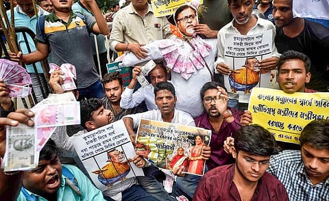 Members of Chhatra Parishad protest against West Bengal Minister Partha Chatterjee with fake currencies after he was arrested by ED officials. (Photo | PTI)