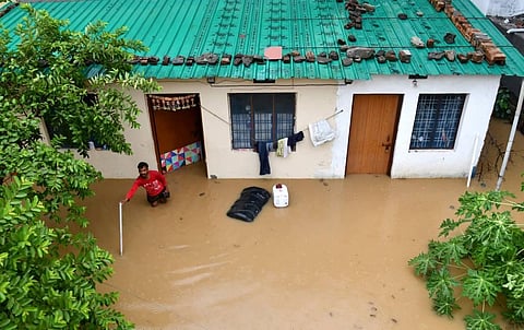 A man at his waterlogged house after monsoon rain in Dehradun, Saturday, July 2, 2022. (Photo | PTI)