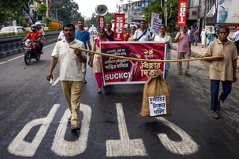 Members of SUCI carrying fake currencies bag during their protest rally against former West Bengal Minister Partha Chatterjee after he was arrested by ED officials. (Photo | PTI)