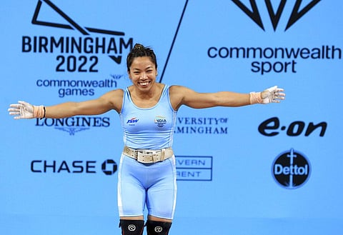 India's Chanu Saikhom Mirabai celebrates on her way to winning the gold medal in the Women's 49kg weightlifting event. (Photo | AP)