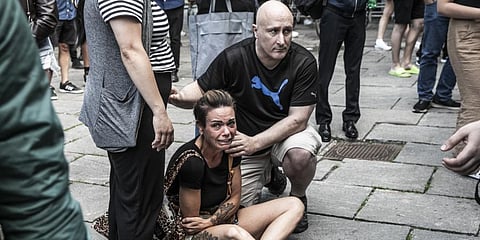 People help a woman in front of the Fields shopping center in Copenhagen, Denmark, Sunday, July 3, 2022.(Photo | AP)