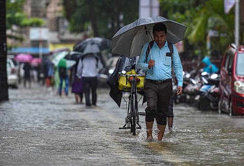 People wade through a water-logged street following monsoon rains, in Mumbai, Tuesday, July 5, 2022. (Photo | PTI)
