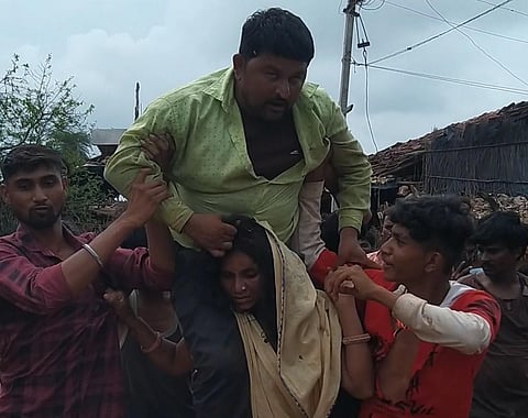 The tribal woman being forced to parade with husband on shoulders in Borpadav village of Dewas district on Sunday. (Photo | EPS)