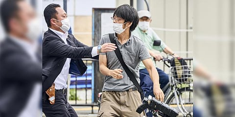 Tetsuya Yamagami (holding a weapon), the assassin of ex-PM Shinzo Abe, is detained near the site of gunshots in Nara on Friday (Photo | AP)