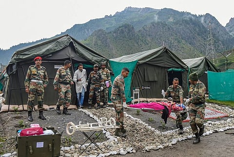 Army soldiers carry an injured pilgrim evacuated from cloudburst areas near the Amarnath cave shrine by a helicopter, at Baltal in Ganderbal district. (Photo | PTI)