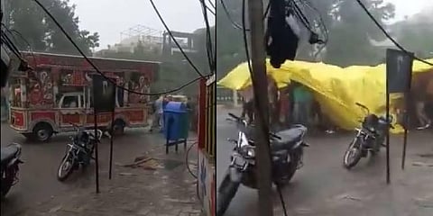 A group of people taking cover under a massive yellow-colored tarpaulin enjoying a marriage procession amid heavy downpour. (Photo | Dipanshu Kabra Twitter)