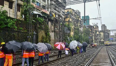 BMC workers repair after a small portion of a wall collapsed between Masjid and Sandhurst Road stations following heavy rainfall, in Mumbai. (Photo | PTI)