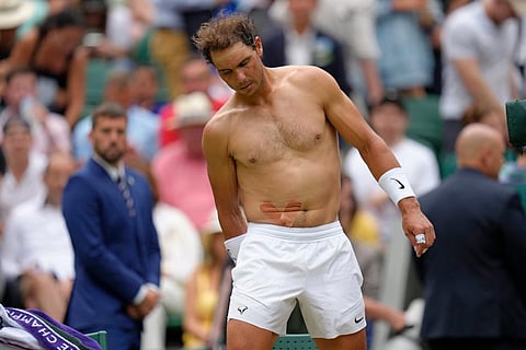 Spain's Rafael Nadal sports tape on his stomach following a medical timeout as he plays Taylor Fritz of the US in a men's singles quarterfinal match on day ten of the Wimbledon tennis championships in