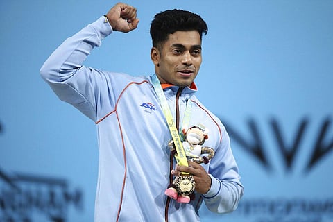 India's Achinta Sheuli, center, celebrates with his gold medal as he stands on the podium following the Men's weightlifting 79kg Final. (Photo | AP)