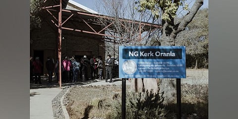 Worshippers gather outside at a Dutch Reformed Church in Orania. (Photo | AFP)