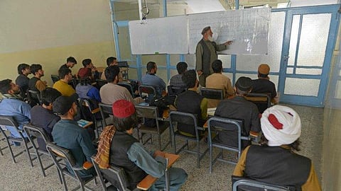 Members of the Taliban with their classmates attend an economic faculty class at a private university in Kabul. (Photo | AFP)