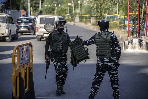 An Indian soldier passes a bulletproof vest to a colleague near the site of a grenade attack on a security force post in Srinagar. Representational image. (File Photo | AP)