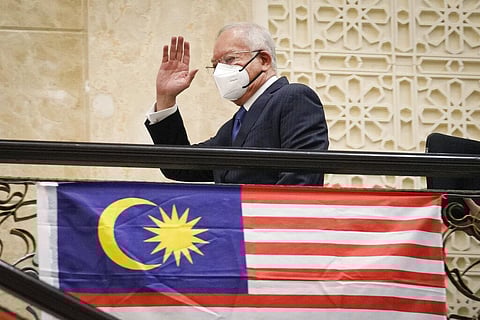 Former Malaysian Prime Minister Najib Razak, wearing a face mask, waves as he arrives at Court of Appeal in Putrajaya, Malaysia. (Photo | AP)