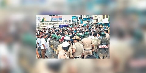 A mob argues with police personnel at Amir Ahmed Circle in Shivamogga city on Monday. (Photo | Express)