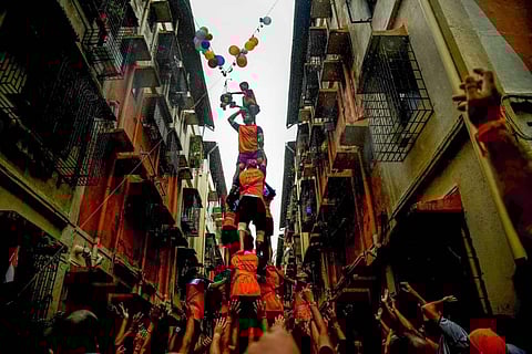 Devotees from a human pyramid to break the 'dahi handi' during the celebrations of 'Krishna Janmashtami' festival, at a society in Navi Mumbai. (Photo | PTI)