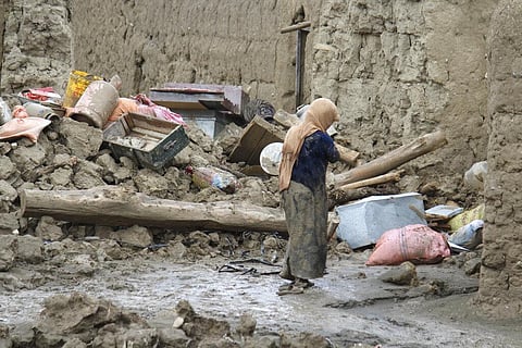 A woman walks by her damaged homs after heavy flooding in the Khushi district of Logar province south of Kabul, Afghanistan, Sunday, Aug. 21, 2022.(Photo | AP)