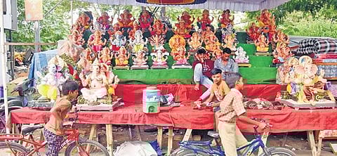 Children in bicycles pass through a shop selling idols of Lord Ganesha at Erragadda in Hyderabad on Thursday | Jwala
