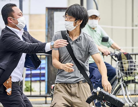 Tetsuya Yamagami, center, holding a weapon, is detained near the site of gunshots in Nara, western Japan Friday, July 8, 2022. (Photo | AP)