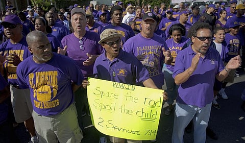 Supporters of St. Augustine High School including Byron Bernard, class of 1980, center, with 'Spare the Rod, Spoil the Child' poster, demand the right of self-governance. (Photo | AP)