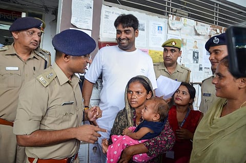 Police hands over the 7-month-old boy to his mother after he was recovered from Firozabad in a corporator's house, in Mathura, Monday, Aug. 29, 2022. (Photo | PTI)