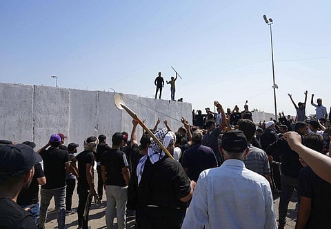 Supporters of Shiite cleric Muqtada al-Sadr try to remove concrete barriers in the Green Zone area of Baghdad, Iraq, Monday, Aug. 29, 2022. (Photo | AP)