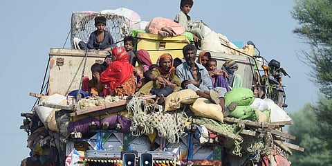 Displaced people sit on a tractor with their belongings as they make their way to reach a safer place after fleeing from their flood hit homes in Sindh.(Photo | AFP)