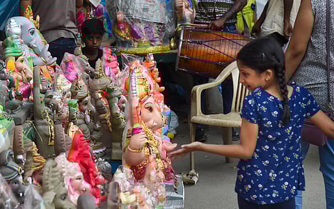 A girl reacts as her family buys Lord Ganesha idol ahead of the festival of 'Ganesh Chaturthi' (Photo | PTI)