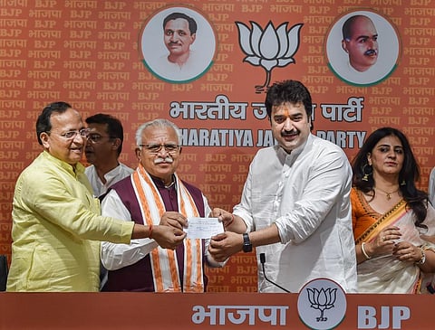 Former Congress leader Kuldeep Bishnoi receives membership slip from BJP National General Secretary Arun Singh and Haryana CM Manohar Lal as he along with his wife Renuka joins the party. (Photo | PTI