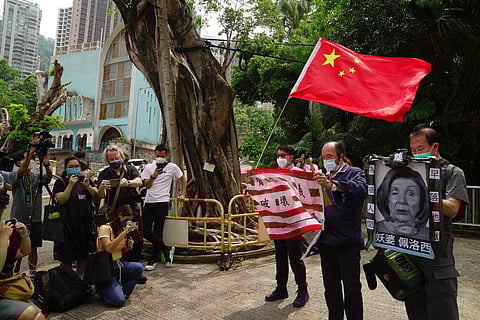 Pro-China supporters hold U.S. flag and a picture of U.S. House Speaker Nancy Pelosi during a protest outside the Consulate General of the United States in Hong Kong. (Photo | AP)