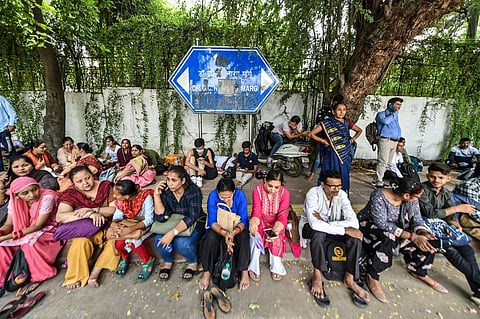 Family members wait at the Delhi University as students appear in the Common University Entrance Test (CUET) 2022, in New Delhi. (Photo | PTI)