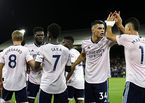 Arsenal players celebrate after Crystal Palace's Marc Guehi scores an own goal past his goalkeeper during the English Premier League soccer match. (Photo | AP)