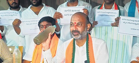 BJP MP and Telangana president Bandi Sanjay Kumar display a bottle filled with contaminated drinking water reportedly being supplied to people in the Bhongir district, during his Praja Sangrama Yatra.