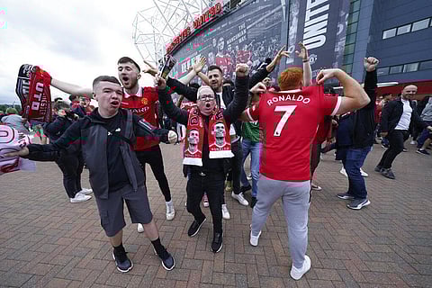 Fans wearing shirts and scarves of Manchester United's Cristiano Ronaldo cheer outside the stadium. (Photo | AP)