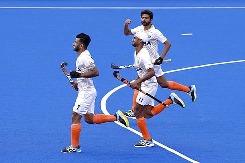 India players Manpreet Singh, left, and Sandeep Singh, centre, celebrate their teams first goal during the hockey match between India and Wales. (Photo | AP)