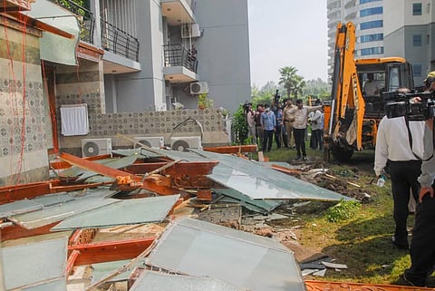 Residents gather as Noida authority carries out demolition of illegal construction at the Grand Omaxe society, in Noida. (Photo | PTI)