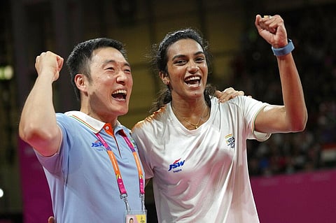India's Venkata Sindhu Pusarla celebrates with a coach Tae Sang Park after winning in the Women's singles badminton at the Commonwealth Games. (Photo | AP)
